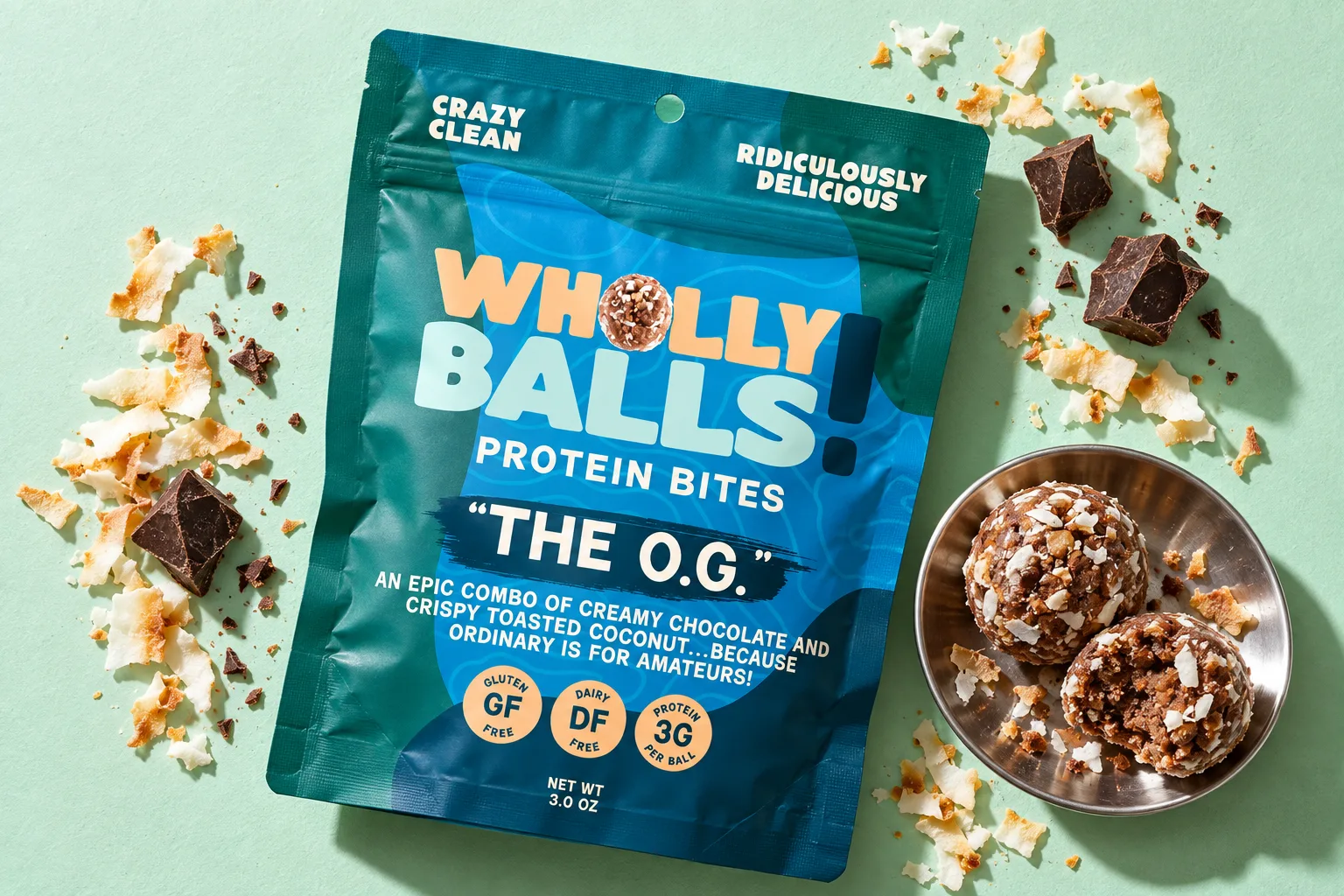 An O.G. pouch on a mint ground with toasted coconut, dark chocolate and a dish of protein bites