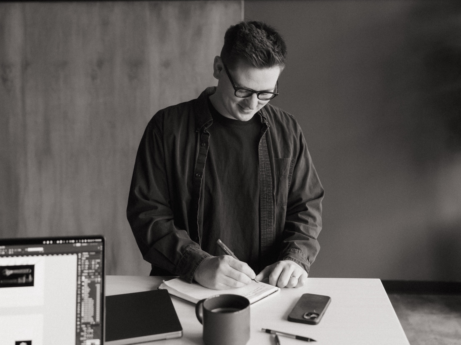 Quinn sketching in a notebook at his studio desk